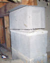Concrete crawl space support posts in East Peoria that are showing signs of failure as they sink into the earth.