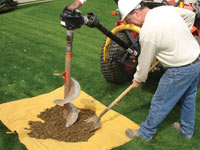 Auguring a hole in the earth for a foundation wall repair system in Clinton