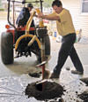 Digging a hole in the garage floor to make room for a wall anchor installation in La Salle, Illinois and Iowa