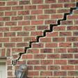 stair step cracking reaching from a window along the foundation wall in Davenport