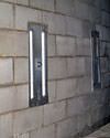 an inside view of foundation wall anchors installed along a basement wall to brace and repair the structure in Bettendorf