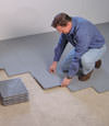 Contractors installing basement sub floor tiles and matting on a concrete basement floor in Iowa City, Illinois and Iowa